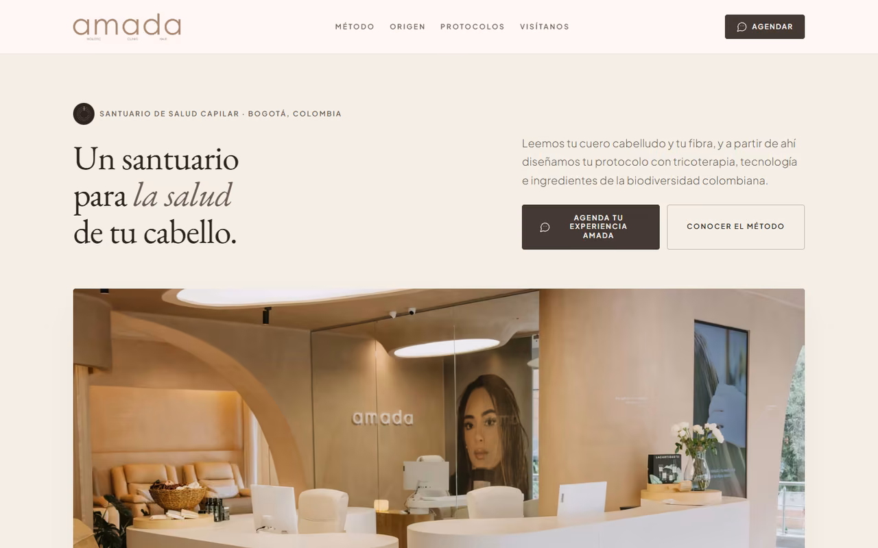 Página de inicio de amadaholistic.com en escritorio con el titular «Un santuario para la salud de tu cabello» y foto de la recepción