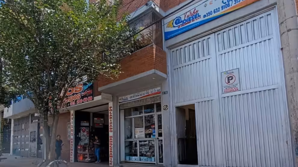 Fachada del laboratorio Turbo Diesel de Colombia GD en Bogotá: portón blanco y aviso con el logo y los teléfonos